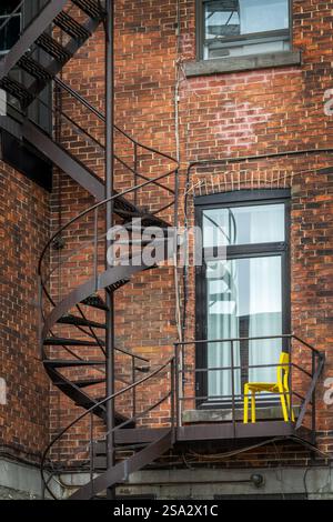 Escalier extérieur en spirale métallique rouillé sur un bâtiment en briques à Montréal, au Canada Banque D'Images
