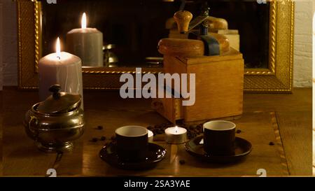 Un moulin à café vintage, des bougies, des tasses à moka. Banque D'Images