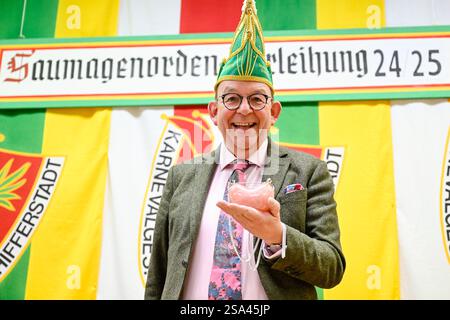 Schifferstadt, Allemagne. 28 janvier 2025. Denis Scheck, critique littéraire, tient le prix entre ses mains avant la cérémonie de remise des prix du 32e Palatinat 'Saumagen-Orden'. Le 'Saumagen-Orden' en quartz rose est décerné chaque année par la société de carnaval et de danse 'Schlotte'. Crédit : Uwe Anspach/dpa/Alamy Live News Banque D'Images