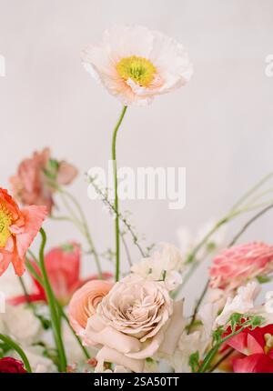 Arrangement floral avec des fleurs vibrantes aux couleurs douces dans un cadre intérieur moderne Banque D'Images