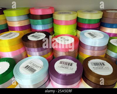 Rouleaux de ruban de satin coloré sur l'affichage dans diverses nuances et textures. Banque D'Images
