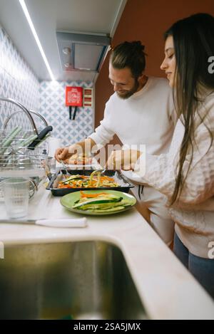 Un couple profite d'une expérience culinaire délicieuse ensemble dans leur cuisine moderne et élégante Banque D'Images