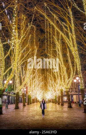 Les habitants de Seattle profitent d'une promenade nocturne sous les lumières de Noël enchanteresses de Occidental Square à Pioneer Square, Seattle. Banque D'Images