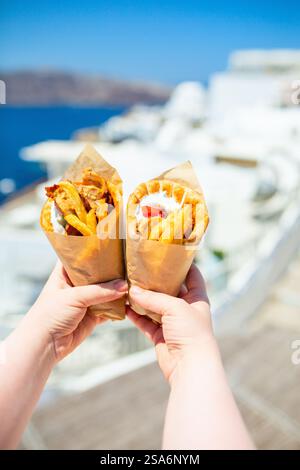 Gyros grecs enveloppés dans du pain pita photographié contre la ville grecque traditionnelle avec des maisons blanches Banque D'Images
