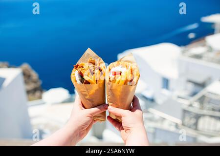 Gyros grecs enveloppés dans du pain pita photographié contre la ville grecque traditionnelle avec des maisons blanches Banque D'Images