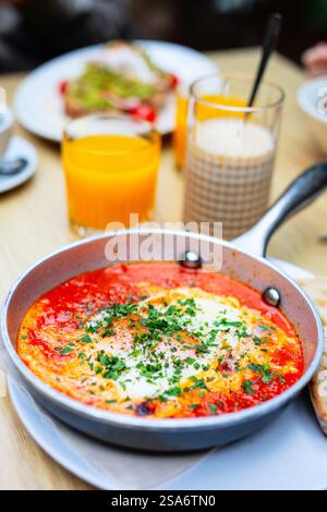 Délicieux œufs shakshuka en sauce tomate avec fromage feta servis dans une poêle pour le petit déjeuner Banque D'Images