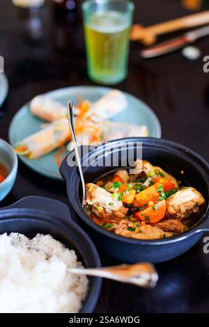 Délicieux déjeuner de poulet, riz, légumes et rouleaux de printemps servis au restaurant Banque D'Images