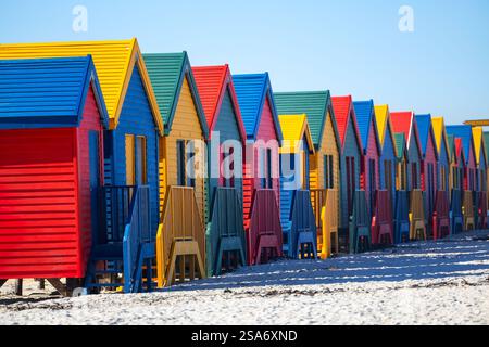 Rangée de boîtes à langer de style victorien bleu, jaune, rouge et vert distinctif sur pilotis le long du célèbre littoral sablonneux de Muizenberg Banque D'Images