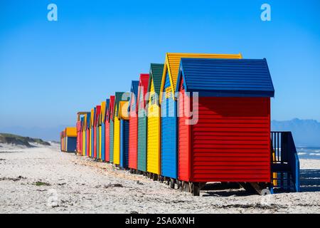 Rangée de boîtes à langer de style victorien bleu, jaune, rouge et vert distinctif sur pilotis le long du célèbre littoral sablonneux de Muizenberg Banque D'Images