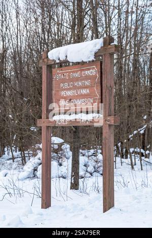 Une enseigne en bois de Pennsylvania Game Commission dans les bois en hiver à Deerfield Township, Pennsylvanie, États-Unis Banque D'Images