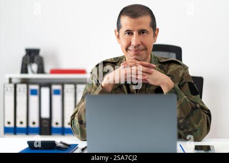 Photo recadrée d'un beau soldat adulte dans son bureau et regardant la caméra Banque D'Images