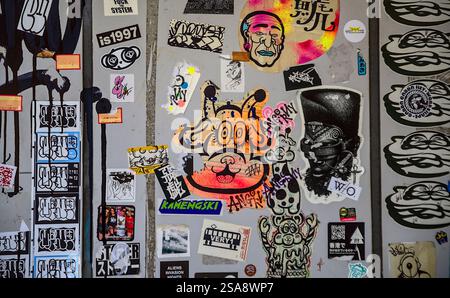 Vue rapprochée d'un mur avec une variété colorée d'autocollants et de graffitis dans l'ouest de Tokyo Banque D'Images