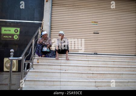 La Mecque, Arabie Saoudite - 13 juin 2024 : deux vieux pèlerins du Hadj et de l'Oumrah venus d'Indonésie assis devant un hôtel à Makkah, Arabie Saoudite. Hajj 2024 Banque D'Images