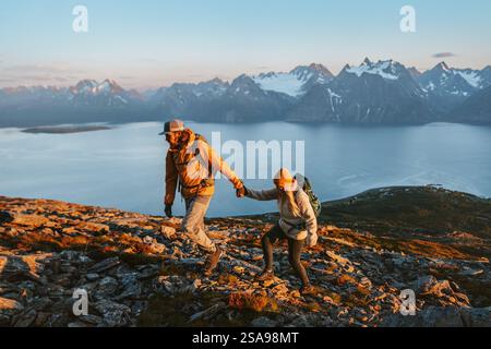 Couple tenant les mains homme et femme randonnée dans les montagnes ensemble explorer la Norvège touristes avec sac à dos style de vie sain en plein air vacati famille active Banque D'Images