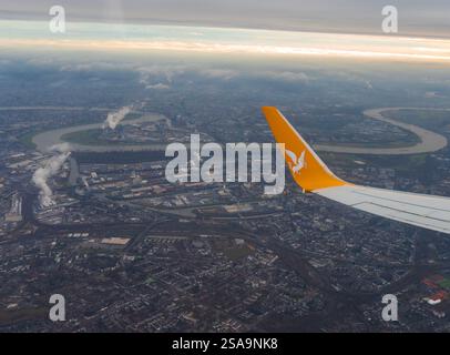 Vue aérienne de Düsseldorf avec le bout des ailes de Pegasus Airlines. La zone industrielle, le Rhin et le paysage urbain sont visibles sous un ciel nuageux. Banque D'Images