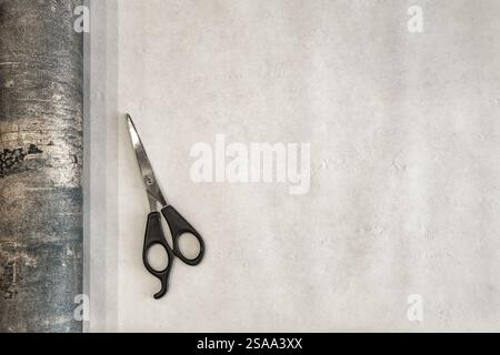 Couper le papier peint avant de le coller au mur, ciseaux, ruban à mesurer et crayon sur la table, couper le papier peint à la taille Banque D'Images