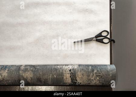 Couper le papier peint avant de le coller au mur, ciseaux, ruban à mesurer et crayon sur la table, couper le papier peint à la taille Banque D'Images