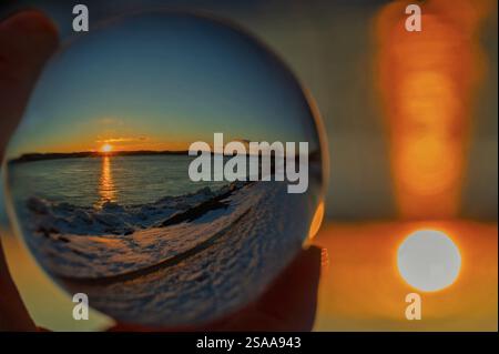 Reflet du lever du soleil dans une boule de verre en hiver Banque D'Images