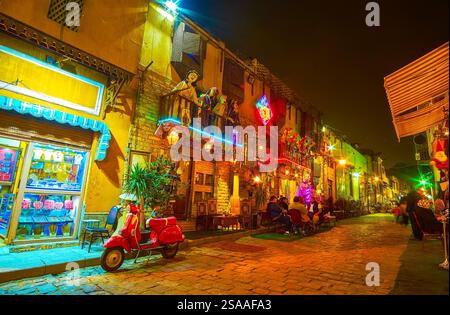 Promenade de fin de soirée au Caire islamique, avec vue sur une ruelle de la rue Al Muizz avec des boutiques touristiques, des petits étals et des maisons de thé, Egypte Banque D'Images