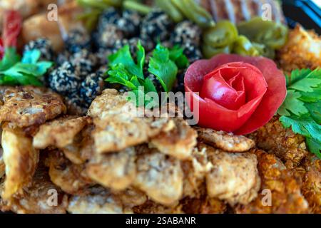 Un plateau coloré avec des plats gastronomiques magnifiquement agencés avec une garniture en forme de rose Banque D'Images