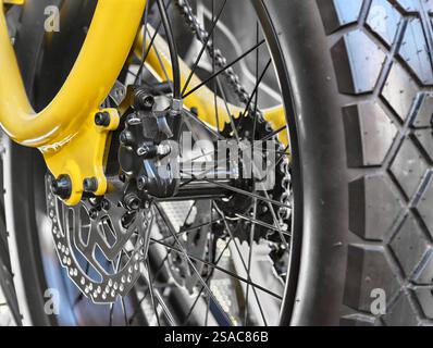 Explorer les détails complexes d'une roue de vélo jaune éclatante, mettant en valeur l'artisanat et le design à chaque virage Banque D'Images