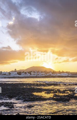Coucher de soleil à Playa Vista Lobos, dans une longue exposition au bord de la mer, plage de lave avec vue sur la ville de Corralejo, Fuerteventura, îles Canaries, Espagne, EUR Banque D'Images
