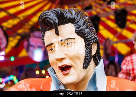 WETZLAR, ALLEMAGNE - 05 JUILLET 2024 : Portrait d'ELVIS PRESLEY Doll à une foire près d'un Break Dance Ride en Allemagne. Banque D'Images