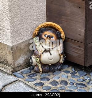 Statue de Tanuki portant un chapeau et tenant le bâton à Kyoto japon Banque D'Images