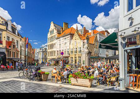 Bruges, Belgique, 5 juillet 2023 : les gens traînent dans le restaurant de rue et les cafés sur la place du marché aux œufs Eiermarkt, vieux bâtiments médiévaux dans Bruges vieux Banque D'Images