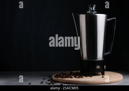 Cafetière sur fond noir avec des grains de café. Copier l'espace Banque D'Images