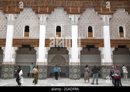 Ben Youssef madrasa (medersa), Marrakech, Maroc. Touristes dans la cour centrale Banque D'Images