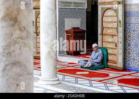 Fidèle assis et lisant Kuran dans le mausolée Moulay Driss i, (Maqam Moulay Idriss), Moulay Idriss Zerhoun, Maroc Banque D'Images