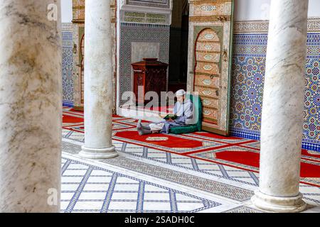 Fidèle assis et lisant Kuran dans le mausolée Moulay Driss i, (Maqam Moulay Idriss), Moulay Idriss Zerhoun, Maroc Banque D'Images