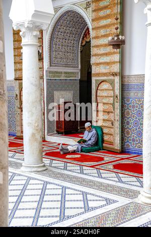 Fidèle assis et lisant Kuran dans le mausolée Moulay Driss i, (Maqam Moulay Idriss), Moulay Idriss Zerhoun, Maroc Banque D'Images