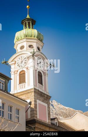 Horloge tour sur l'hôtel de ville à Innsbruck, Autriche. Innsbruck repère sur une journée ensoleillée en hiver. Ancienne église et montagnes des Alpes sur fond, Innsbruck. Banque D'Images