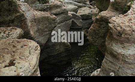 L'eau sombre coule à travers un étroit canyon creusé dans la roche, créant un spectacle naturel fascinant Banque D'Images