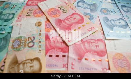 Billets de banque chinois en yuan dispersés sur une surface présentant diverses coupures de 10 à 100 yuan, mettant en évidence la conception détaillée de la monnaie an Banque D'Images