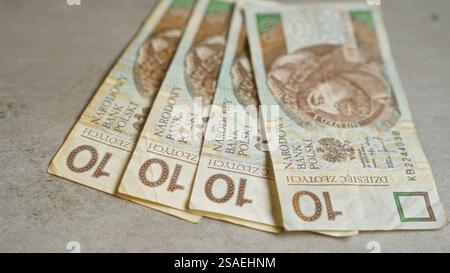 Billets de banque polonais de 10 zloty placés sur une surface en béton, mettant en évidence la monnaie de la pologne dans un contexte financier. Banque D'Images