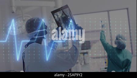 Image de l'électrocardiographe au-dessus de divers médecins inspectant la radiographie Banque D'Images