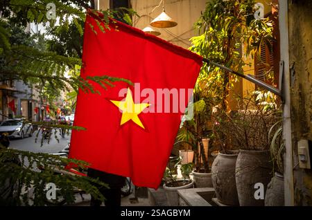 Drapeau vietnamien rouge et jaune suspendu devant une maison à Chau long St, Hanoi, Vietnam. Banque D'Images