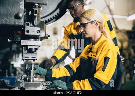 soutien d'équipe travaillant dans l'usine de l'industrie des métaux lourds formant les jeunes femmes travailleuses, inspecteur contrôle de la qualité dans la chaîne de production. Banque D'Images