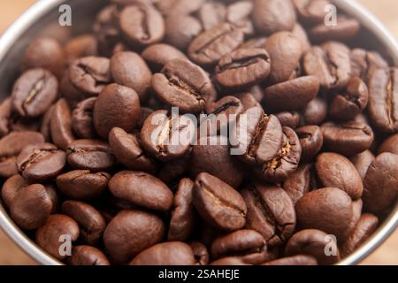 Grains de café arabica torréfiés dans une tasse en métal. Prise de vue macro Banque D'Images
