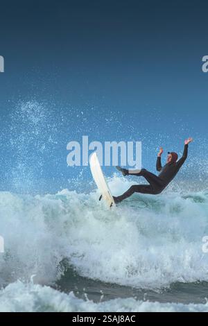 Un surfeur s'effondre sur une grosse vague à Fistral à Newquay en Cornouailles au Royaume-Uni. Banque D'Images
