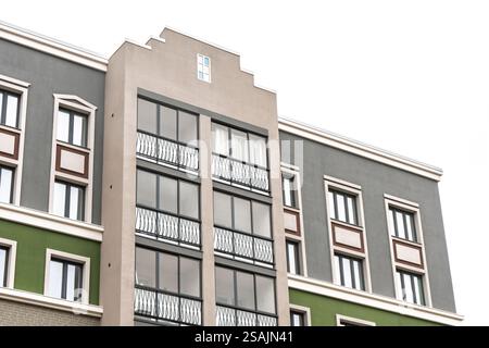 Immeuble résidentiel de plusieurs étages avec façade moderne, avec de grandes fenêtres en verre et des balcons en métal, isolé sur blanc Banque D'Images