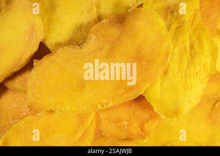 Chips de mangue séchées saines sans sucre ajouté gros plan plein écran comme arrière-plan. Banque D'Images