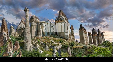 Montgolfières survolant les spectaculaires formations rocheuses de renommée mondiale de la 'Love Valley' au lever du soleil, près de Goreme, Cappadoce, Turquie. Banque D'Images
