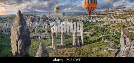 Montgolfières survolant les spectaculaires formations rocheuses de renommée mondiale de la 'Love Valley' au lever du soleil, près de Goreme, Cappadoce, Turquie. Banque D'Images