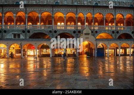 Vue en soirée du Palazzo della Ragione et de la Piazza delle Erbe à Padoue, Vénétie, Italie, avec des arches illuminées et des reflets sur le trottoir humide après rai Banque D'Images