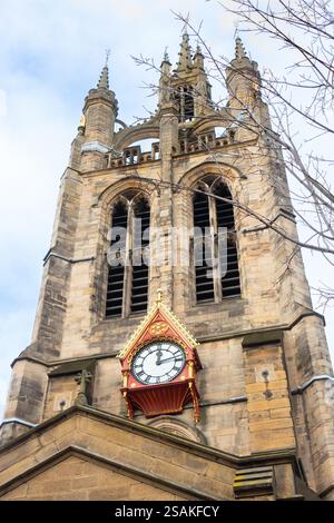 Imposante tour d'horloge en pierre de la cathédrale historique de newcastle sur tyne avec une architecture complexe contre un ciel nuageux Banque D'Images