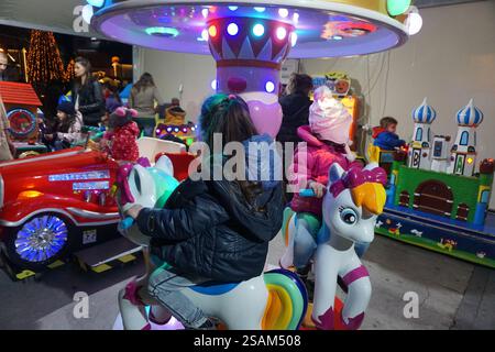 Les enfants jouent sur des jouets tels que des chevaux et des voitures automatiques pendant Noël et le nouvel an Banque D'Images
